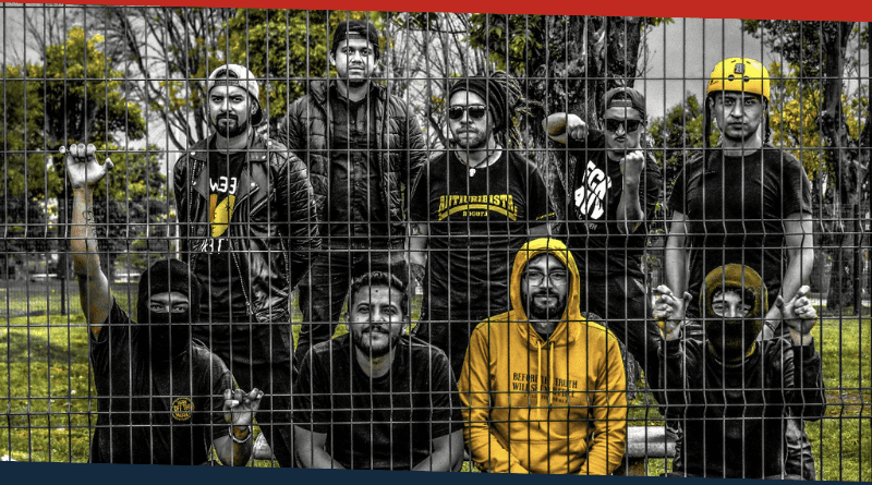 Nueve personas en la foto detrás de una reja. Foto de El Punto Ska.